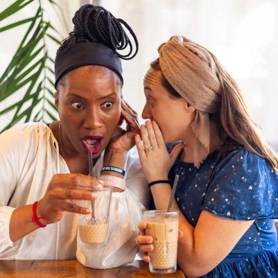 Woman whispering to friend 2