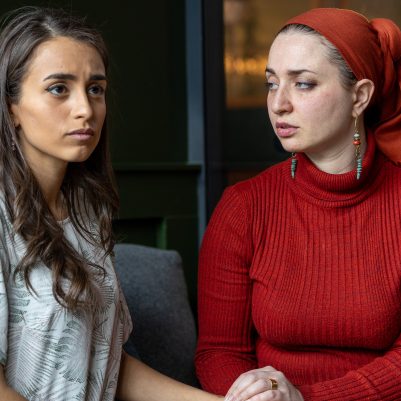 Woman comforting friend sitting on couch