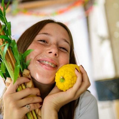 Teenager smiling with lulav and etrog
