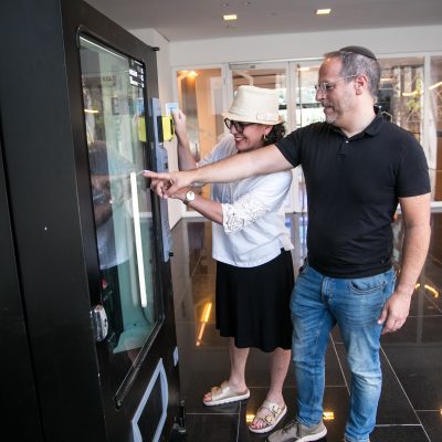 Couple choosing snack from vending machine 2