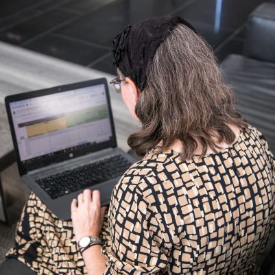 Woman sitting on couch working on laptop 3
