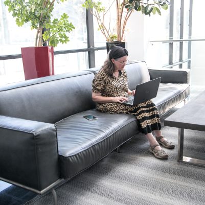 Woman sitting on couch working on laptop 5