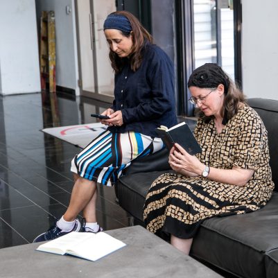 Two women studying book on couch 5