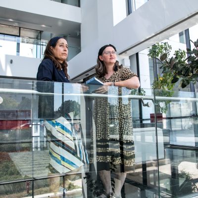 Two women talking and holding siddurs 3