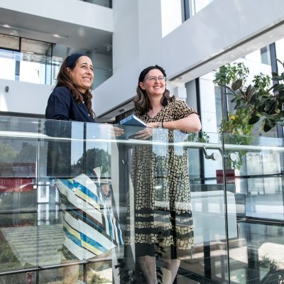 Two women talking and holding siddurs 4