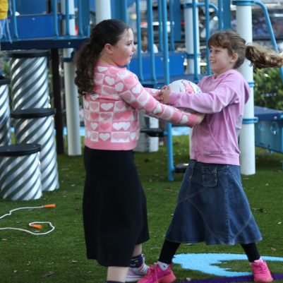 Two Girls Playing Together in an Outdoor Playground Setting