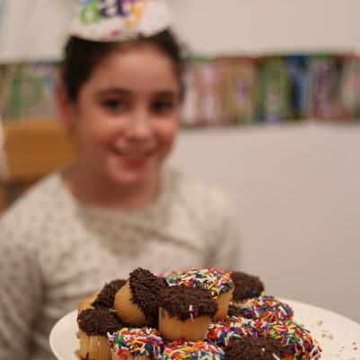 Birthday Cupcake and Happy Young Girl at Home Celebration