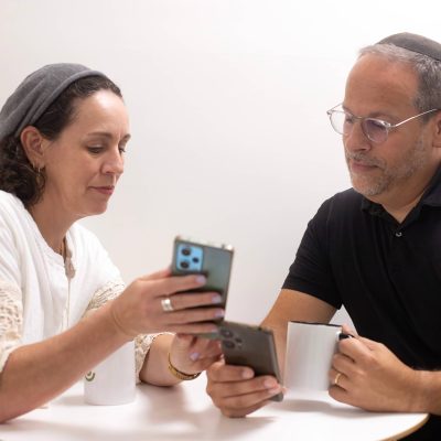 Man and Woman Looking at Their Phones Together