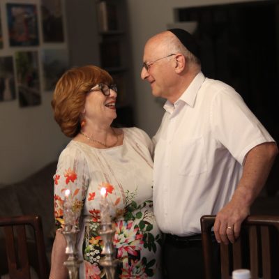 Smiling Woman and Man Looking at Each Other at a Candlelit Table