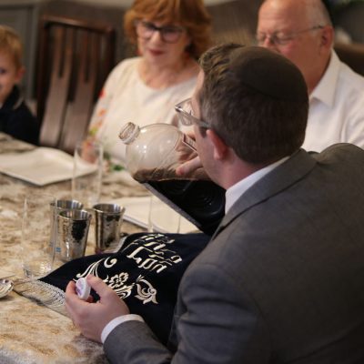 Man Pouring Wine into a Glass for the Ceremony with His Family