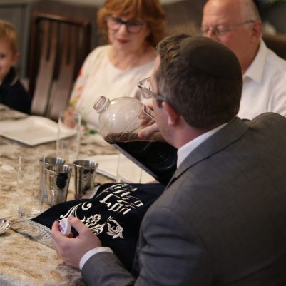 Man Pouring Wine into a Glass for the Ceremony with His Family
