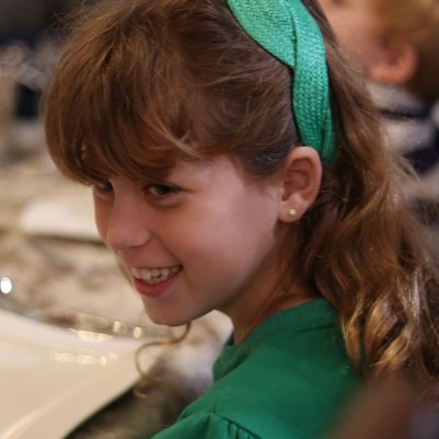 Happy Young Girl Enjoying a Family Dinner at Home