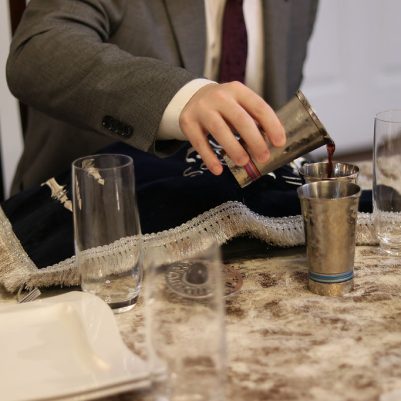 Man Pouring Wine into a Glass for the Ceremony at the Family Table