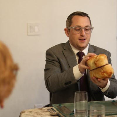 Man Holding Challah Bread While Preparing at Table