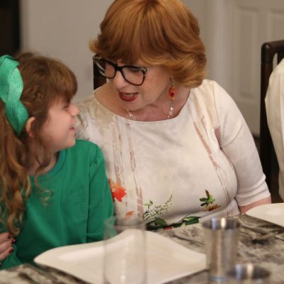 Woman and Young Girl Talking at the Family Table During Dinner