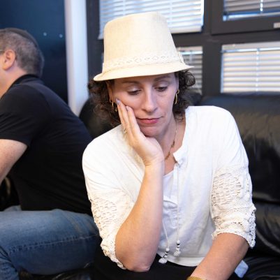 Worried Woman Resting Face on Hand, Man Sitting in Background