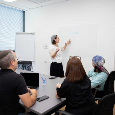 Professional Woman Leading Team Meeting and Presenting Business Updates on Whiteboard