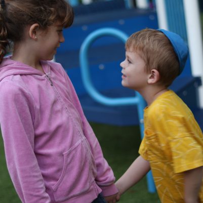 Young Boy and Girl Holding Hands During Outdoor Playtime