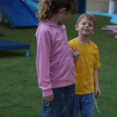 Young Boy and Girl Holding Hands While Walking in a Playground