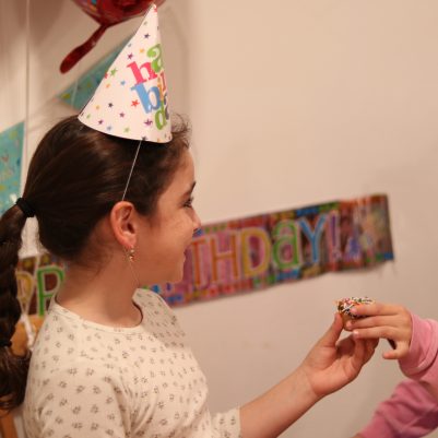Young Birthday Girl Sharing a Cupcake with a Friend
