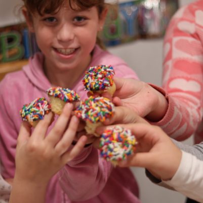 Group of Young Girls Enjoying Cupcakes at an Indoor Birthday Celebration