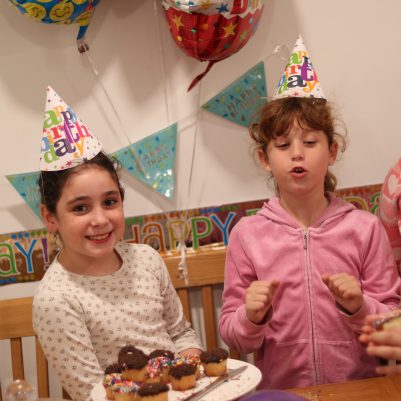 Group of Young Girls Celebrating a Birthday with Cupcakes and Party Decorations