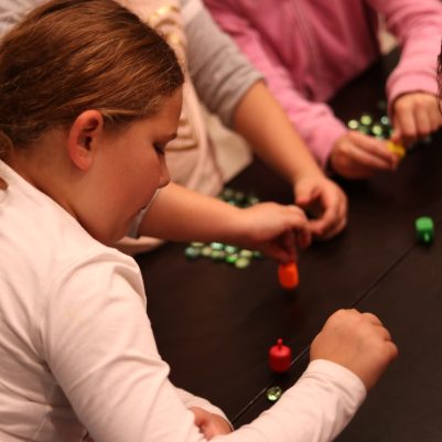 Young Girl Playing the Dreidel Game with Friends