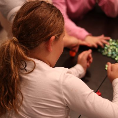 Young Girl Enjoying the Dreidel Game with Friends