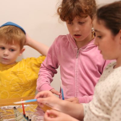 Young Children Lighting a Candle Together