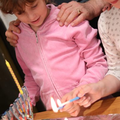 Young Girls Lighting Candles During a Holiday Celebration