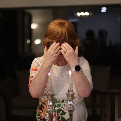 Elderly Woman Covering Eyes While Praying