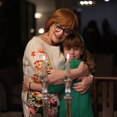 Elderly Woman Hugging Child During Traditional Candle Ritual