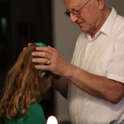 Close-Up Photo of an Elderly Man and Young Girl During a Blessing and Prayer Ceremony