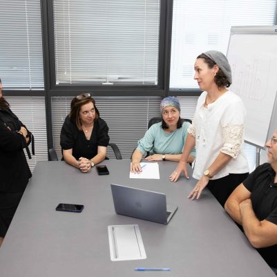 Two Women Debating in Front of Team at Business Meeting