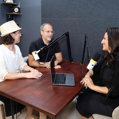 Two Women and One Man Recording a Storytelling Podcast in Professional Studio