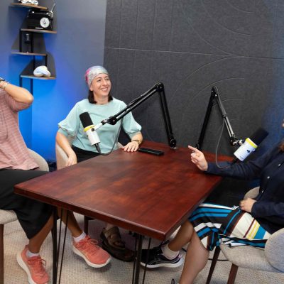Three Women Recording a Podcast and Sharing Fun Stories in a Studio